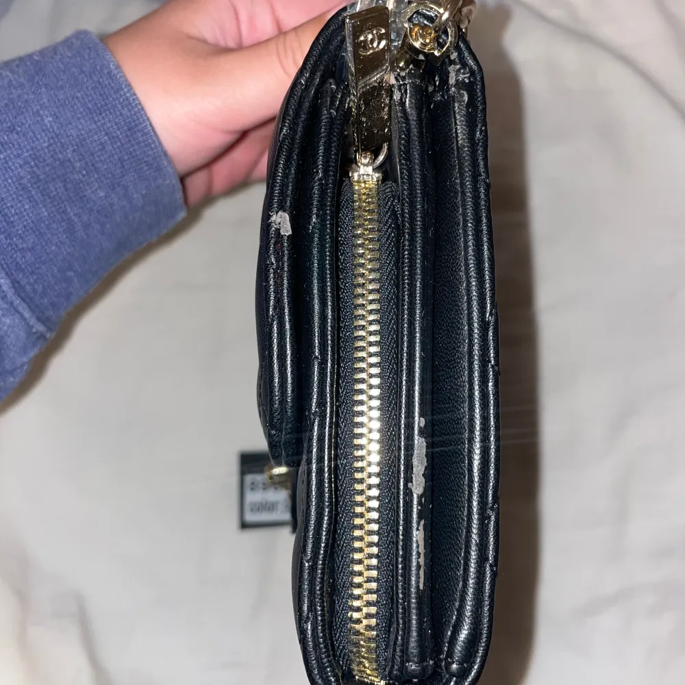 Svart väska som liknar Chanel.  Axelremsväska med band som går att ha i två lägen. . Väskor.