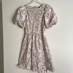 Sommarklänning  - Super fin sommarklänning med puffärmar. Köpt för ett år sen och använd 1 gång. Två snören i bak som knyts i övrigt en öppen rygg:)