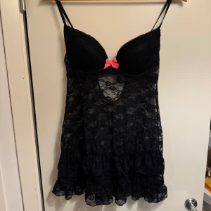 Svart nattlinne med spets och rosa rosett - Rosa rosett och baksida vid bhn, storlek M. Svart nattlinne i spets, superfint. 