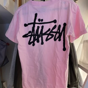 Stüssy T-shirt  - Sjukt snygg och unik ljusrosa T-shirt från Stüssy i storlek S! Jag har endast använt den 1 gång! Köpte den på plick🩷🩷🩷