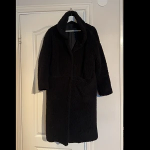 Svart kappa - Storlek XS, väldigt snygg och skön kappa. Sparsamt använd.