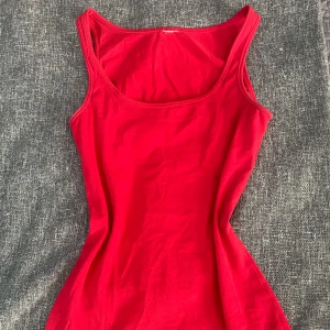 röd topp - en snygg röd topp som är köpt secondhand men som inte kommer till användning, är lite längre än vanliga toppar. skulle säga att den sitter som en S. har en liten fläck men som inte syns på. kontakta mig för bilder på och köparen står för frakten 💕