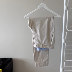 Beige Massimo Dutti Byxor  - Lätta beiga byxor från Massimo Dutti i nyskick. Nypris 850 kr. Made in Portugal. Storlek: 48 Material: 98% Bomull, 2% Elastan  