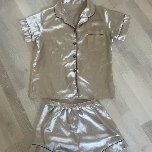 Silkespyjamas  - Säljer denna jättesköna silkespyjamasen från shein då jag har i andra färger. Den ser ganska guldig ut på bilderna men är mer åt det rosa hållet. Står ingen storlek i men tror xs 