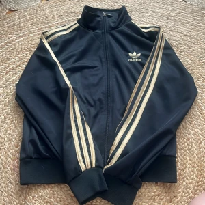 Adidas kofta  - Säljer helt oanvänd adidas kofta i guld och svart, jätte bra skick 🖤💛