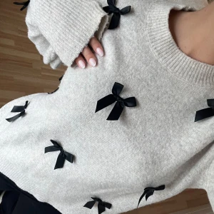 stickad tröja  - så himla söt men har tyvärr tröttnat trotts att jag använt den lite. inga rosetter baktill! 