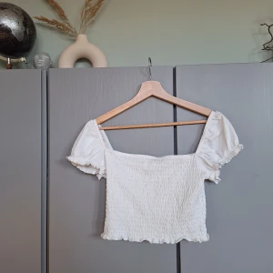 Vit offschoulder topp, blus, sommartopp, smockad topp 🥰❤️ - Vit offschoulder topp, blus, sommartopp, smockad topp. Strl M enligt lappen men den är liten och motsvarar strl S. Missa inte mina andra annonser ❤️🥰