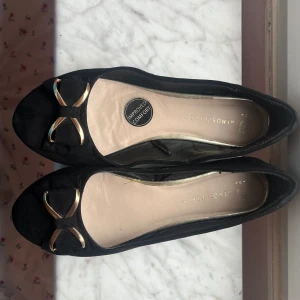 Svarta ballerinaskor med gullig rosett - Söta svarta ballerinaskor med Hilding rosett på, passar jätte bra till utekväll! Har använts ganska mycket men är fortfarande i bra skick! 💕
