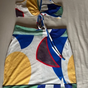 Färgglatt set - Jättefint set med kjol och topp som man knyter. Har endast provat det, har aldrig använt.