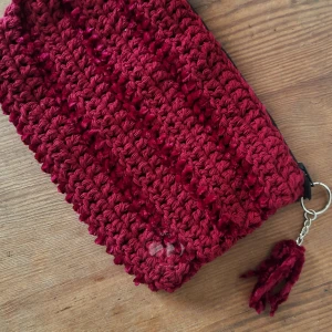 Virkad sminkväska | Crocheted makeup bag - Hand made crocheted makeup bag. It has a zipper closure and a keychain attachment. 24×16 cm