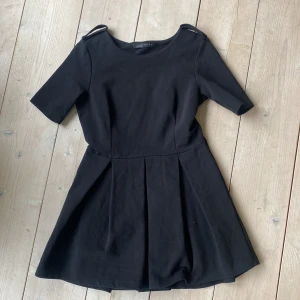 Zara klänning - Fin svart klänning, veckad kjol och detaljer på axlarna Stl L men passar M Knappt använd!