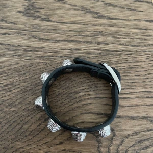 Balenciaga armband - BALENCIAGA, armband i präglat skinn med silvriga nitar, storlek M, längd ca 21 cm. Väldigt fint skick, har dessvärre inte kvar kartong eller kvitto då detta var en gåva.