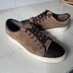 Lanvin cap toe brun - Lanvin cap toe brun. Brun mocka och skinn.   Storlek 42, men är stor i storleken.   Hyfsat bra skick 7/10 några små skråmor, kan ses i bilden.   Pris: 1500kr plus frakt 📦  