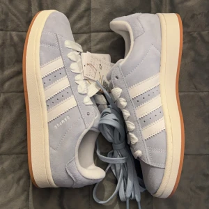 Campus ljusblåa 39 1/2 - Helt Nya - Hej alla skoälskare! Säljer ett par oanvända ljusblåa Adidas Campus i storlek 39 1/3. Dessa trendiga (slutsålda) och bekväma skor är inköpta från JD Sports. Finns i Örebro för upphämtning, men kan även skicka dem till dig. 