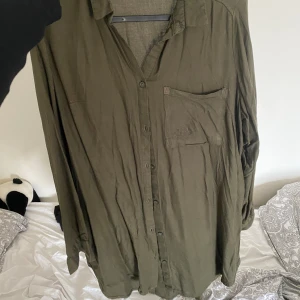 Olivgrön skjorta/tunika - Olivgrön skjorta/tunika Storlek : 42 Lite mindre ”skada” vid fickan som finns, men inte så märkvärdigt