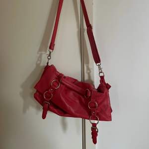 Jättefin röd väska med gulddetaljer, går att justera längden så man kan ha den både som axelremsväska och som vanlig axelväska❣️