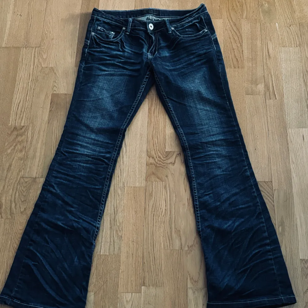 Lågmidjade mörkblåa bootcut jeans från Redial, snygga detaljer på baksidan, midjemått 40cm, innerben 83cm,. Jeans & Byxor.