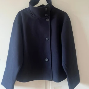 Vårkappa - Mörklblå kort kappa från Gina tricot perfekt till våren. Helt ny och aldrig använd, därav priset. Säljer pga fel storlek. Skriv för fler frågor! Kommer ej gå ner i pris, använd gärna köp nu!💕