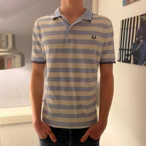 Snygg Fred Perry piké som passar perfekt till sommaren eller till golfrundan! Modellen är 1.84 cm lång