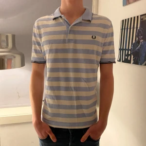 Fred Perry piké  - Snygg Fred Perry piké som passar perfekt till sommaren eller till golfrundan! Modellen är 1.84 cm lång