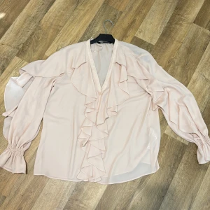 Volang skjorta  - Ljusrosa volang skjorta i st M oanvänd 