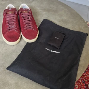 Saint Laurent Skor - Säljer nu mina röda Saint Laurent skor, stl 40 men passar lite större. Skick 7/10 mockan är lite smutsig men borde gå att få bort om man tvättar dem. Skopåse och extra skosnören ingår. Priset kan diskuteras, skriv vid frågor eller funderingar!