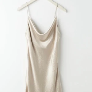 Klänning  - En beige (lite guldig) silkes klänning från Gina Tricot. Super fin och skön, passar perfekt till sommaren. Bra och elegant material. Tyvärr är den för stor för mig och slutsåld på Gina Tricot. Frakt ingår med 29kr.