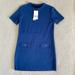 ZARA marinblå klänning med knappar - Otroligt fin klänning från ZARA med guldknappar. Mjukt och mysigt material, perfekt vardags- och jobbklänning. Ny med tags kvar, utan anmärkningar.