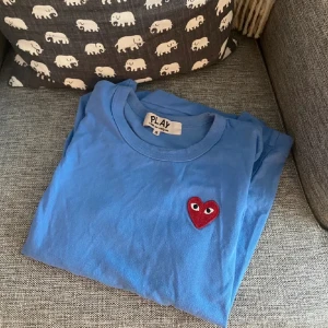 Comme des garçons t shirt - Fin blå färg med bra passform. Är i bra skick förutom att den har en liten fläck (därav priset), synns knappt när man har på sig den om man inte kollar närmare (bild 3). Hör av er vid frågor!