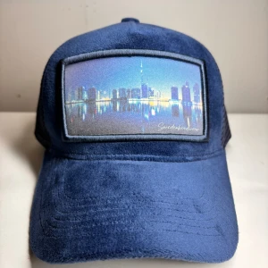 Swedenheadwear keps  - Swedenheadwear keps utav Velvet och en bild av ett torn i dubai. Helt ny inte använd