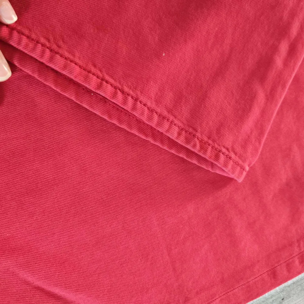 Ett par röda byxor från STAY i storlek L. Byxorna har en normal passform och är tillverkade i ett bomullsmaterial. De har en klassisk design med fem fickor och knappgylf.. Jeans & Byxor.