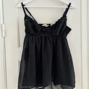 Babydoll spetstopp - Så fin lite längre babydoll topp. Inte helt genomskinlig men ganska, mer tyg mot bysten. Xs. Vintage hm