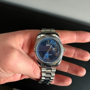 Klocka med blå urtavla - Tjena!  Säljer min helt oanvända klocka från Calithe. Köpt helt ny för 650kr.  Vid frågor/funderingar är det bara att höra av sig på meddelande!