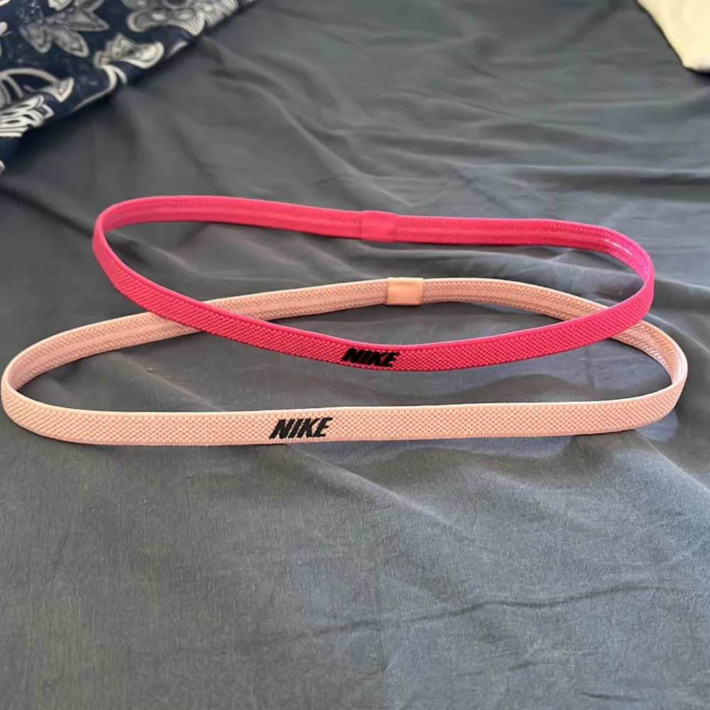 Hårband för att få bort håret under träning. Det ena är i en rätt skrik rosa färg och den andra är lite mer ljus rosa. Aldrig använda! Båda kommer från Nike. Säljes helst tillsammans! 20kr för båda. . Sport & träning.