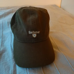 Barbour keps  - Säljer nu en Barbour keps som är köpt på johnells men knappt använd rum 2-3 gånger