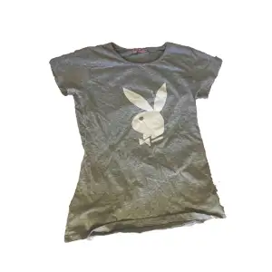 sleek gray Playboy top adorned with the iconic Playboy bunny print. Crafted in size M