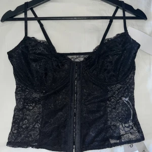 Korsett topp - As snygg svart korsett topp med bygel och justerbara band. Från NA-KD, helt oanvänd med lapparna kvar. Säljer då storleken inte passade.