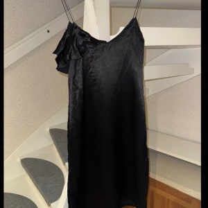 Svart klänning  - Svart klänning med slits på både sidor, vet ej märker men den är i bra skick. Står ingen storlek men passar Xs/s. längd: 100 cm