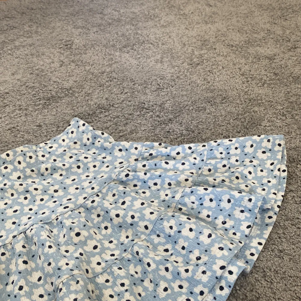 En blå blommig kjol från Lager 157.🩵🤍 köptes för 150kr men säljs för 80kr. ‼️köparen står för frakten‼️ skriv privat för mer information eller bilder. (Kan passa 134/140). Kjolar.