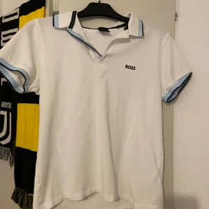 Boss piké  - Vit boss piké med blå och svarta detaljer. Asbra kvalitet👏