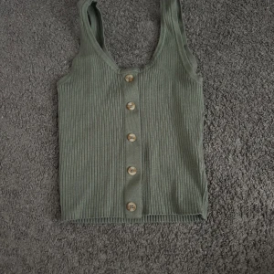 Millitär grönt linne med knappar(går ej att öppna) - Linne från HM i storlek devided,Lite som en magtröja lite kortare!Använd ungefär 2/3 ggr(pga inte min stil!)PM för fler bilder!!