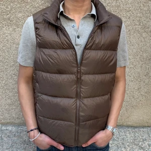 Väst/vest från uniqlo - Säljer denna dun vest i sjukt snygg bryn färg från uniqlo. Det är en ultra light down, som går för 699 i butik.   Storlek M, passar även L. 10/10 skick.   Perfekt till en sommar kväll.