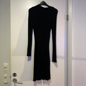 Stretchig svart klänning från Nelly strl XS (ser mindre ut på bild) - Svart tight klänning som främjar siluett. Gott skick 