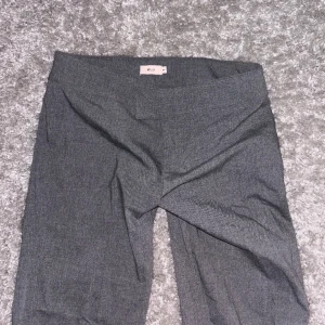 Gråa lågmidjade kostymbyxor från Nelly  - Fina gråa lågmidjade kostymbyxor i storlek 34, väldigt fint skick, använt fåtal gånger.  (Skriv privat för mått)