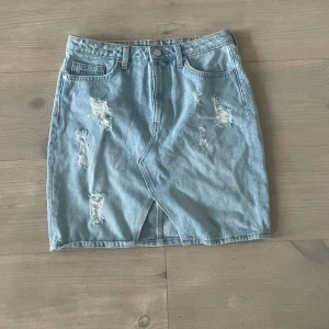 Ljusblå jeanskjol - Jeanskjol, kort sitter lite högmidjat men assnyggt med en stickad tröja över!!