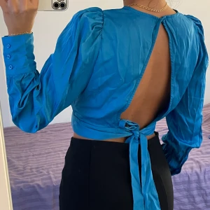 Blå satin topp - Blå satin topp med öppen rygg köpt från vero moda. Använd en gång, storlek xs men kan passa s