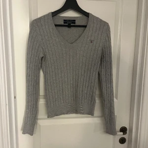 Gant tröja - En grå kabelstickad tröja från gant med v-formad urringning. 