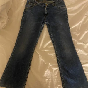 Lågmidjade utsvängda Lee jeans - Bra skick. Var min mammas gammla som jag fick men som inte passade. Längden på jeansen är ganska korta då de passar mig väldigt bra och jag är 160 cm lång