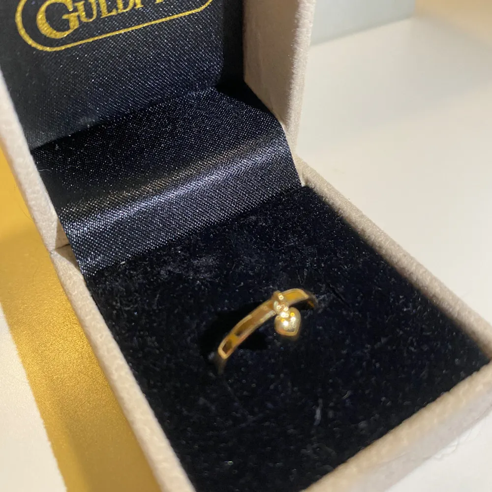 En guldplaterad ring i 18k och väger 0.5g, köptes för 1498kr. Ringen är i storlek 16,5. Heter ”Tunn ring med liten hjärtberlock i 18K guld” på Guldfynd. Aldrig använd pågrund av fel storlek. Säljer för 1000kr men priset kan diskuteras. . Accessoarer.