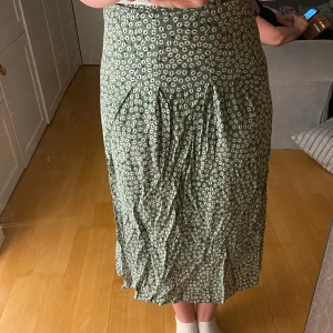 Blommig kjol - Somrig grön långkjol. Dragkedja på sidan, slits på båda sidorna. Använt ett fåtal gånger.